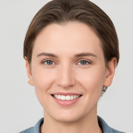 Joyful white young-adult female with short  brown hair and grey eyes