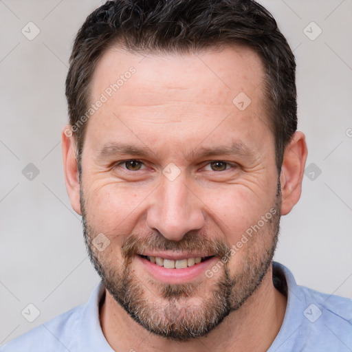 Joyful white adult male with short  brown hair and brown eyes