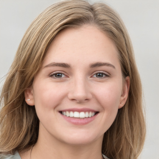 Joyful white young-adult female with long  brown hair and grey eyes