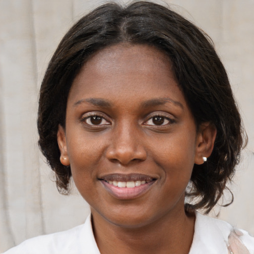 Joyful black young-adult female with medium  brown hair and brown eyes