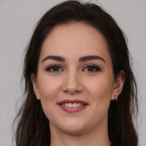 Joyful white young-adult female with long  brown hair and brown eyes