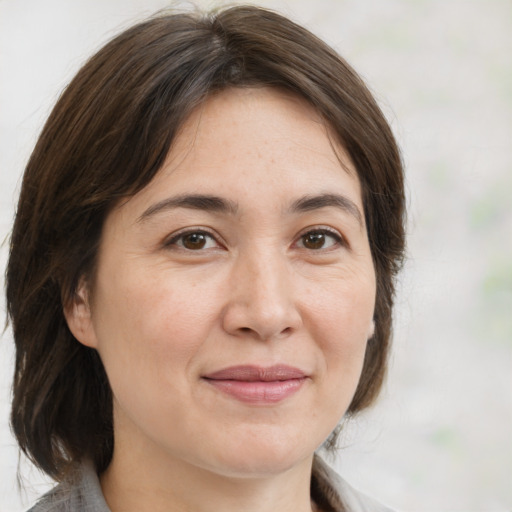 Joyful white adult female with medium  brown hair and brown eyes