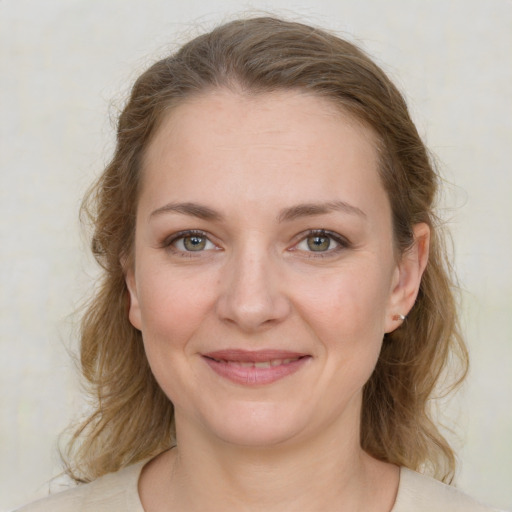 Joyful white young-adult female with medium  brown hair and green eyes