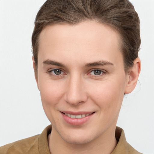 Joyful white young-adult female with short  brown hair and grey eyes