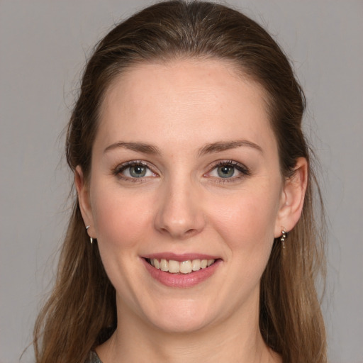 Joyful white young-adult female with medium  brown hair and grey eyes