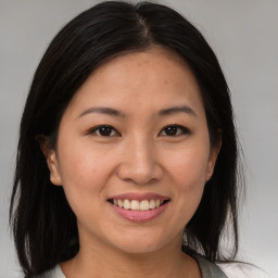 Joyful asian young-adult female with medium  brown hair and brown eyes