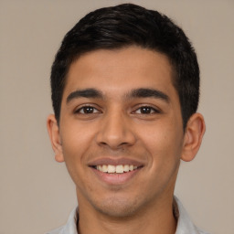 Joyful latino young-adult male with short  black hair and brown eyes