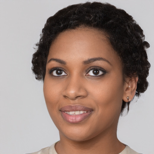 Joyful black young-adult female with short  black hair and brown eyes