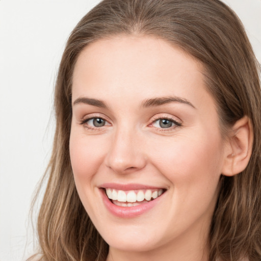 Joyful white young-adult female with long  brown hair and grey eyes