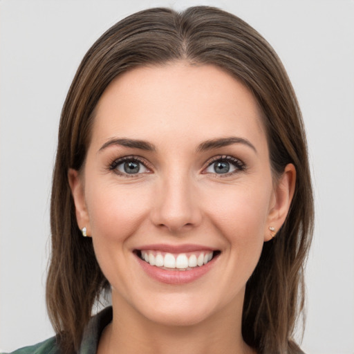 Joyful white young-adult female with long  brown hair and grey eyes