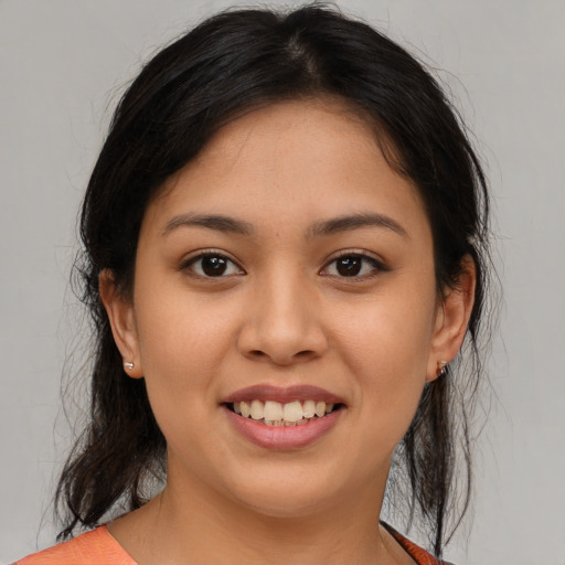 Joyful latino young-adult female with medium  brown hair and brown eyes