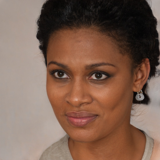 Joyful black young-adult female with short  black hair and brown eyes