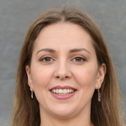 Joyful white young-adult female with long  brown hair and green eyes