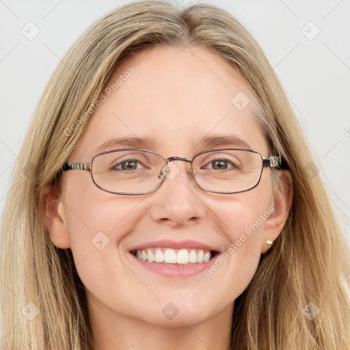 Joyful white adult female with long  brown hair and blue eyes