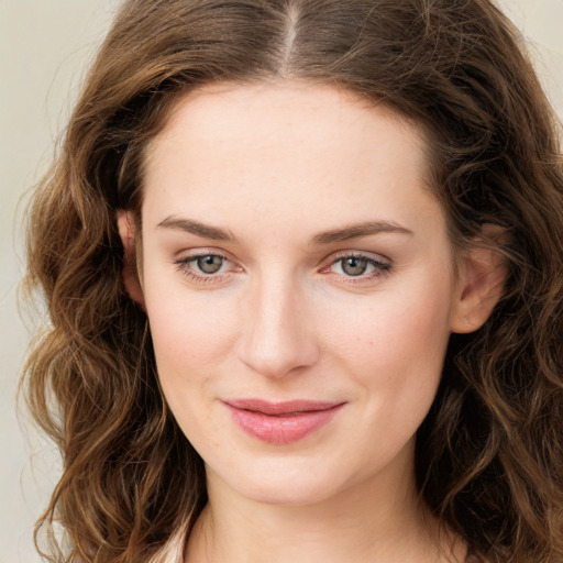 Joyful white young-adult female with long  brown hair and green eyes