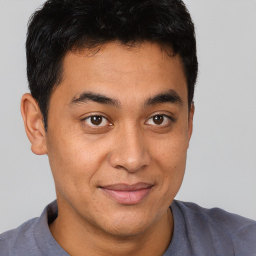 Joyful latino young-adult male with short  brown hair and brown eyes