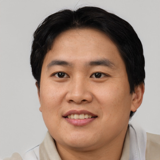 Joyful asian young-adult male with short  brown hair and brown eyes