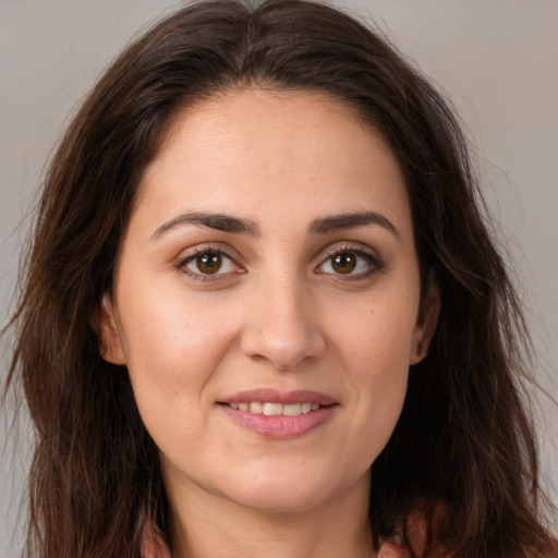 Joyful white young-adult female with long  brown hair and brown eyes