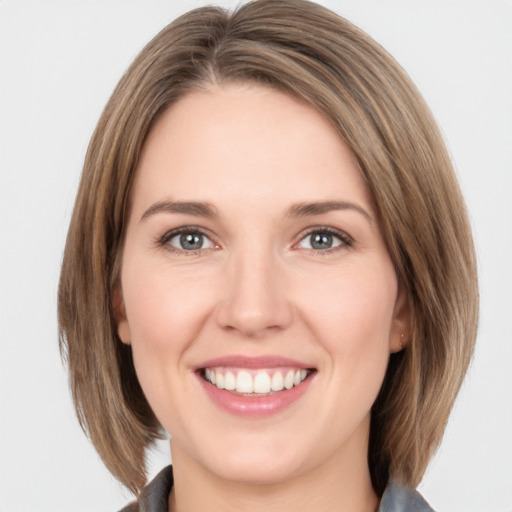 Joyful white young-adult female with medium  brown hair and grey eyes