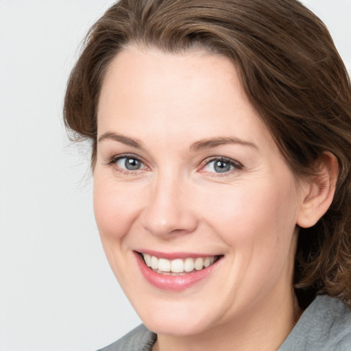 Joyful white adult female with medium  brown hair and grey eyes