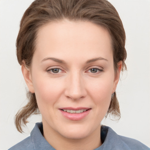 Joyful white young-adult female with medium  brown hair and grey eyes