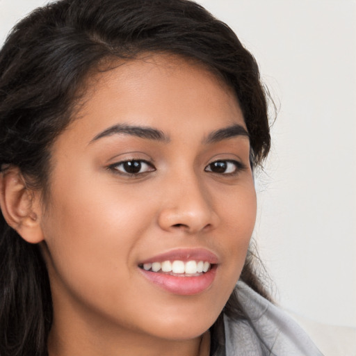 Joyful latino young-adult female with long  brown hair and brown eyes