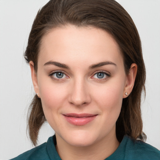 Joyful white young-adult female with medium  brown hair and grey eyes