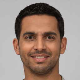 Joyful latino young-adult male with short  black hair and brown eyes