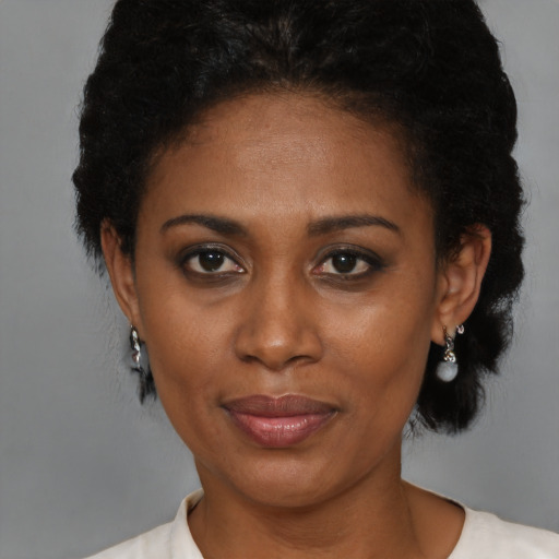 Joyful black adult female with short  brown hair and brown eyes