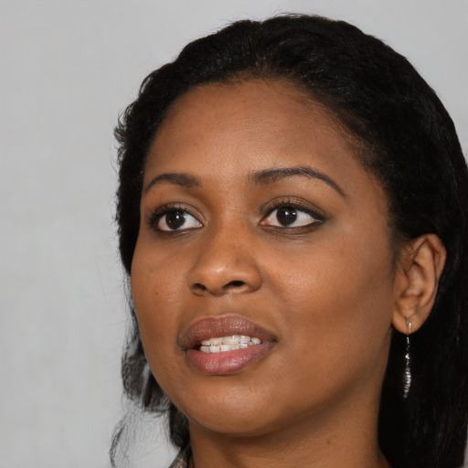 Joyful black young-adult female with long  black hair and brown eyes