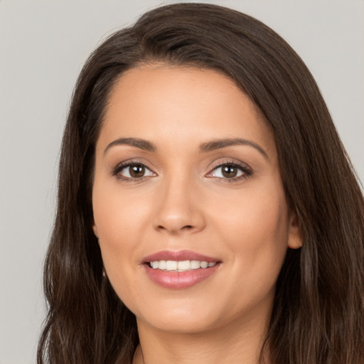 Joyful white young-adult female with long  brown hair and brown eyes