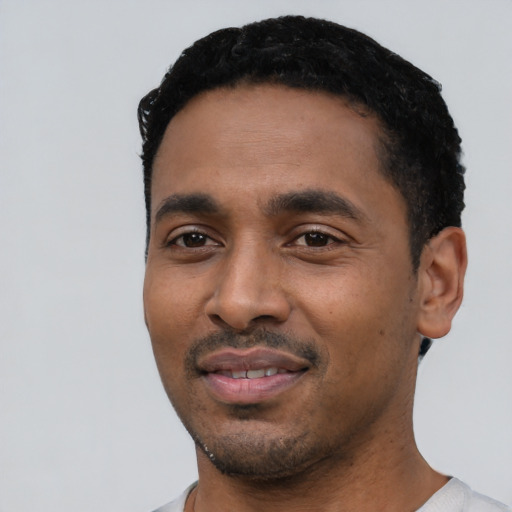 Joyful black young-adult male with short  black hair and brown eyes