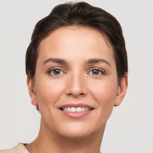 Joyful white young-adult female with short  brown hair and grey eyes