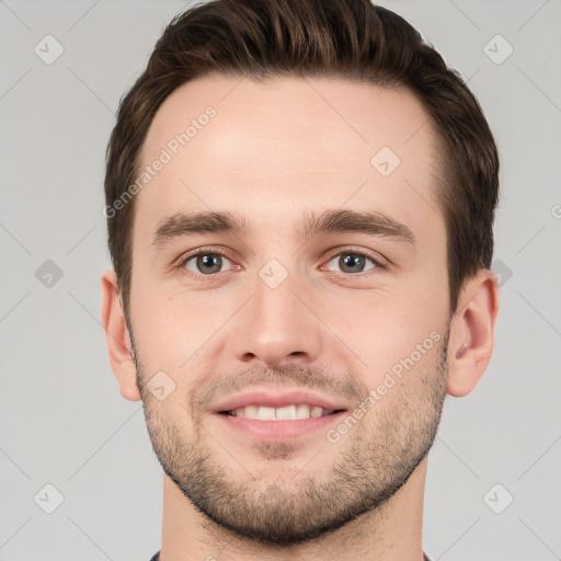 Joyful white young-adult male with short  brown hair and grey eyes