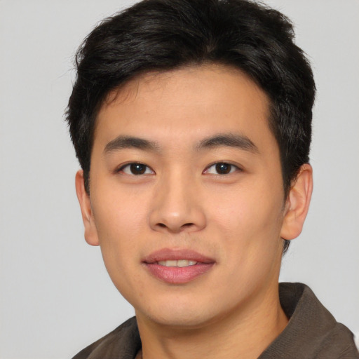 Joyful asian young-adult male with short  black hair and brown eyes