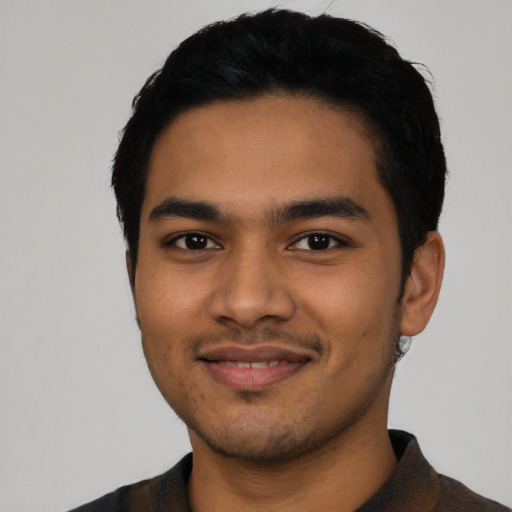 Joyful latino young-adult male with short  black hair and brown eyes