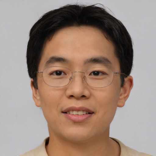 Joyful asian adult male with short  brown hair and brown eyes