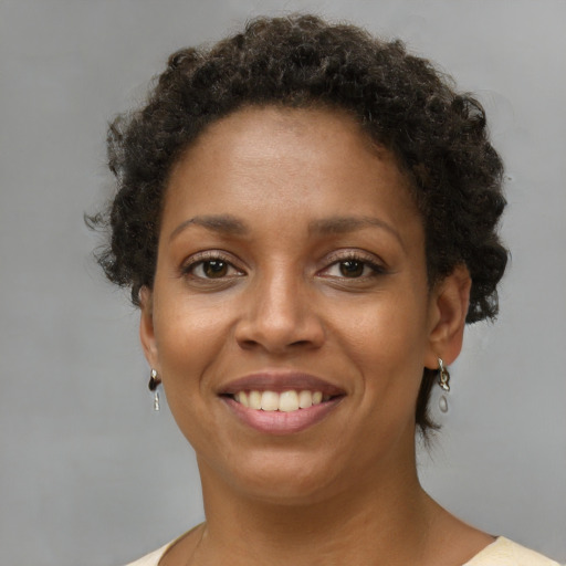 Joyful black young-adult female with short  brown hair and brown eyes
