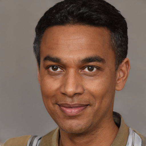 Joyful latino adult male with short  black hair and brown eyes