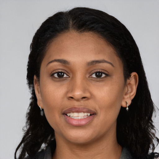 Joyful black young-adult female with long  black hair and brown eyes