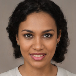 Joyful black young-adult female with medium  brown hair and brown eyes