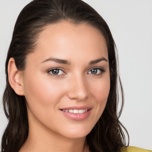 Joyful white young-adult female with long  brown hair and brown eyes