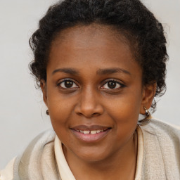 Joyful black young-adult female with long  brown hair and brown eyes