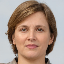 Joyful white adult female with medium  brown hair and grey eyes