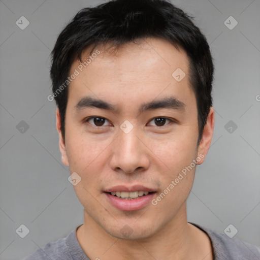 Joyful asian young-adult male with short  black hair and brown eyes