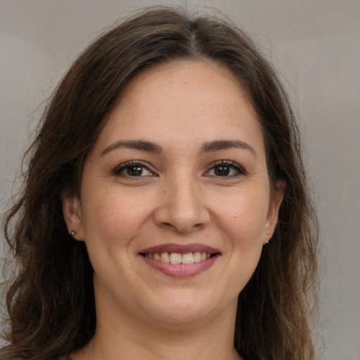 Joyful white young-adult female with long  brown hair and brown eyes