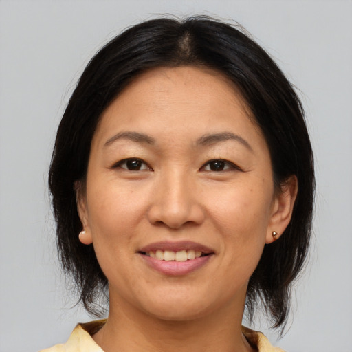 Joyful asian adult female with medium  brown hair and brown eyes