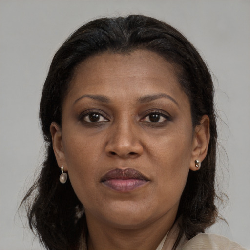 Joyful black adult female with long  brown hair and brown eyes