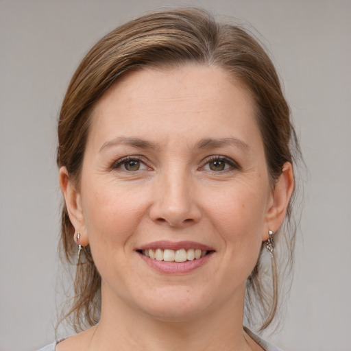 Joyful white adult female with medium  brown hair and grey eyes