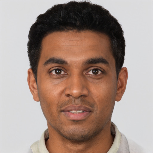 Joyful black young-adult male with short  black hair and brown eyes